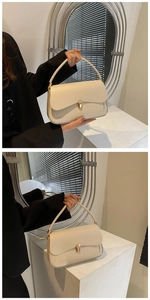 Detailed close-up of cream shoulder bag featuring gold metal lock and leather handle