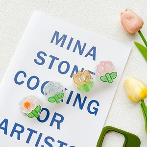 Macro view of four colorful floral pop-up sockets with textured beads on a book