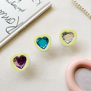 Detailed view of colorful 3D heart-shaped resin phone grips with faceted crystal inlay