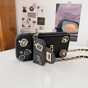 Detail of black quilted iPhone case with camellia, crown charms and crossbody chain