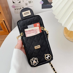 Detail of black quilted phone wallet case with card slots, chain strap and camellia charm