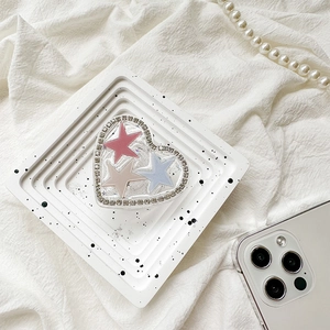 Detail of heart-shaped phone grip with glitter, stars, and rhinestone-encrusted border