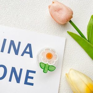 Detail view of a floral phone grip with pink petals and green leaf on white backdrop
