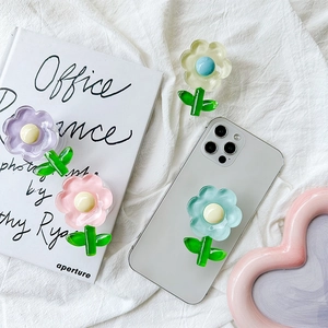 Flat lay of colorful tulip flower phone grips on a white fabric background