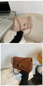 Close-up of stylish shoulder bags in beige and dark brown with elegant gold metal buckles