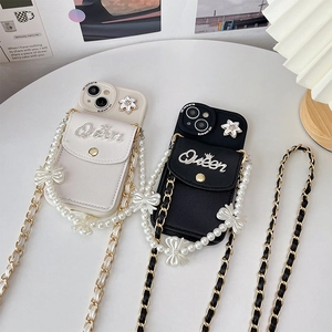 Detail of crossbody phone case with leather card slot and pearl bow chain strap