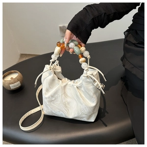 Detail of marble pattern cloud bag featuring colorful resin bead handle and drawstring