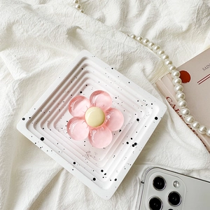 Close-up of pink flower phone grip with resin texture on a modern spotted tray