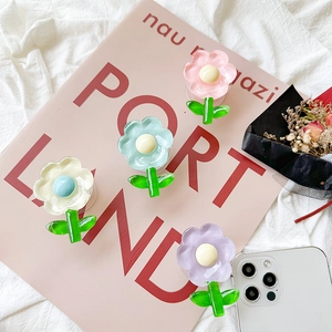 Flat lay of colorful acrylic tulip flower phone grips on a soft aesthetic background