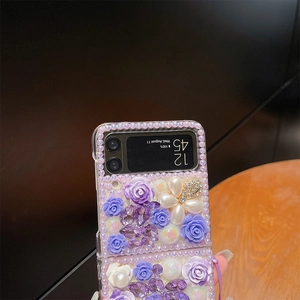 Detail showing 3D purple roses, pearls, and crystals on a Samsung Galaxy Z Flip case