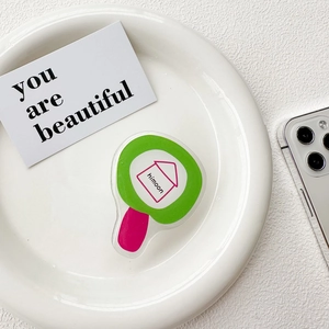 Detailed view of the Himoon acrylic phone grip on a white plate with minimalist aesthetic