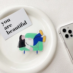 Macro shot of a lazy girl illustration acrylic phone grip on a white decorative plate