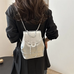 Minimalist silver metallic mini backpack with chain strap and metal lock closure for women