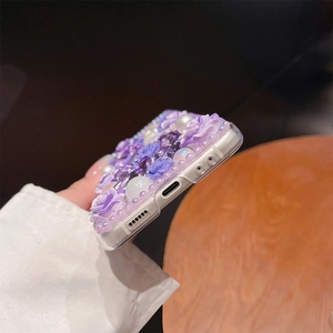 Macro view of purple 3D floral resin and pearl decorations on a sleek phone case
