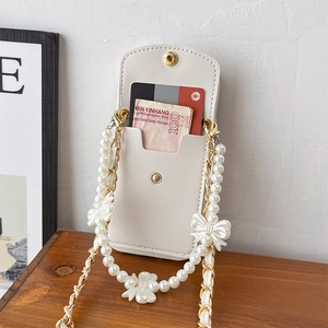 Detail of cream lychee leather phone wallet with card slots and pearl bow strap