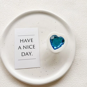 Detail shot of a blue crystal heart phone grip on a white heart base and ceramic tray