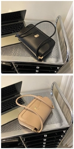 Detail view of black and beige shoulder bags featuring modern gold square buckle closure