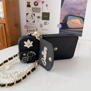 Detail of black leather iPhone case with pearl chain, bow charm and card holder