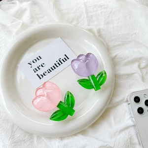 Top view of pink and purple tulip flower phone griptoks on a white ceramic plate
