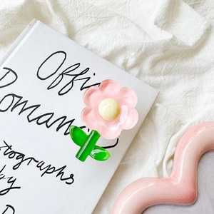 Detailed view of 3D pink tulip flower phone grip tok on a minimalist book background