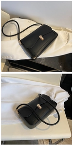 Detail of a black matte rectangular shoulder bag featuring a sleek gold metal buckle closure