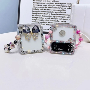 Détail d'une coque Galaxy Z Flip avec papillon en cristal et breloques en perles