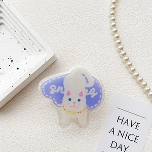 Detail of cute cat acrylic phone grip on white tray with pearl necklace decor