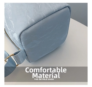 Detail of light blue marble texture fabric and gold metal buckle on a shoulder bag