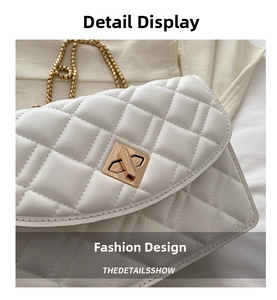 Close-up of white quilted leather bag with champagne gold twist lock and chain strap