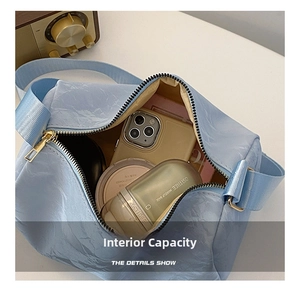 Top view of open light blue cylindrical crossbody bag showing spacious interior capacity