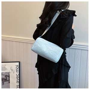 Close-up of light blue cylindrical shoulder bag with unique crinkled fabric texture