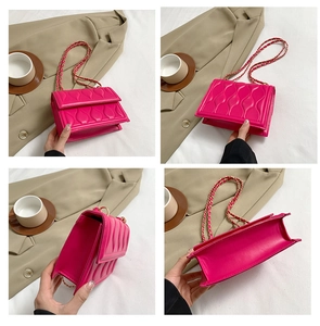 Detail of rose pink wave-stitched crossbody bag featuring golden chain and premium texture