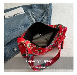 Detail view of red floral canvas crossbody bag interior capacity with everyday items