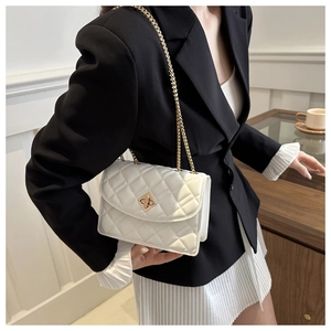Detailed view of white quilted crossbody bag with gold chain strap and metal swivel lock