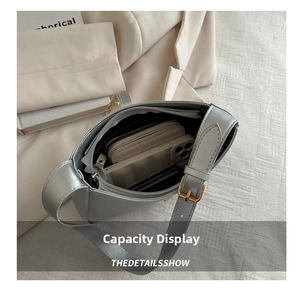 Internal view of the metallic silver shoulder bag showing spacious storage capacity