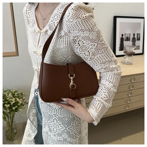 Detail of vintage brown leather underarm bag with gold lobster clasp and lace outfit