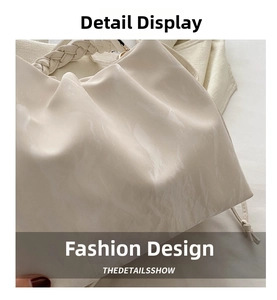 Detailed view of ivory pleated shoulder bag with textured material and woven handle