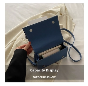 Internal view of a blue faux leather crossbody bag showing phone and wallet capacity