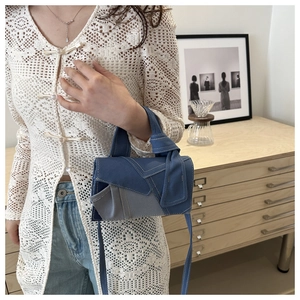 Detailed shot of a patchwork denim mini bag with adjustable strap and fabric texture