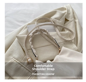 Detail of adjustable metal buckle and woven strap on silk satin crossbody bag