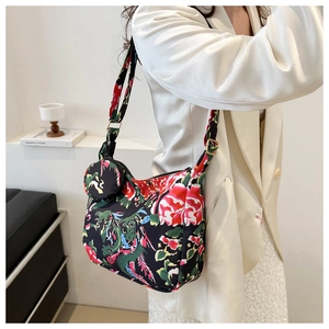 Macro view of floral nylon crossbody bag featuring an ethnic print and mini round pouch