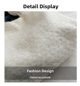Close-up of white bubble textured fabric on a stylish ruched large shoulder bag