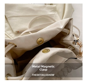 Close-up of magnetic closure and woven handle on beige leather drawstring bucket bag