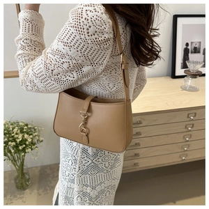 Detail of light khaki leather Boston bag with gold lobster clasp on a casual outfit