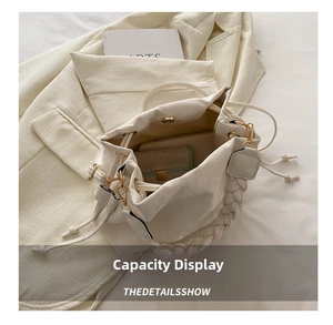 Detail showing spacious cream leather bucket bag interior and woven shoulder strap