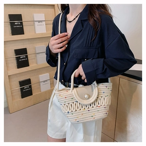 Detail of woven bucket bag with pearl buckle, colorful polka dots and silk scarf