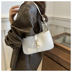 Detail shot of ivory shoulder bag with gold carabiner buckle and sleek faux leather finish