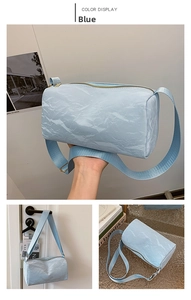 Detail of light blue cylindrical PU shoulder bag with wrinkled texture and wide strap