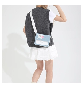 Detail of denim patchwork crossbody bag with star applique and wide shoulder strap