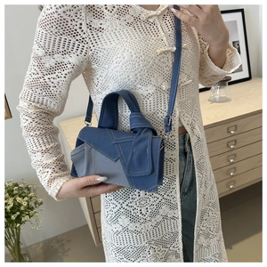 Close-up of denim patchwork crossbody bag showing contrast stitching and textured fabric